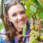 Denise Gardner Holding Grapes in Vineyard